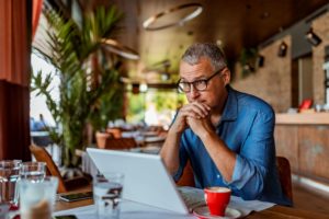 According to the CARES Act, a stimulus check will be treated as a refundable tax credit, and this applies to cases filed before or after enactment of the law. To make filing for bankruptcy easier, the Yaldou Law Firm website features an option that allows residents to file online after a consultation with one of our attorneys. In this image, a concerned man is sitting in a coffee shop in front of a laptop.